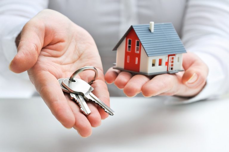 an agent handing house key and home model